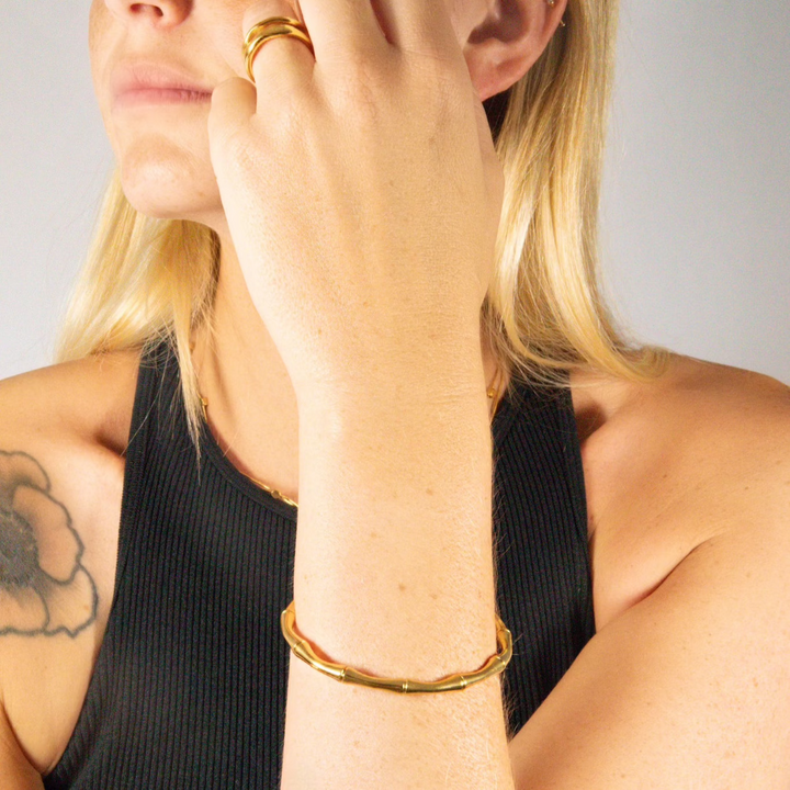 A nature-inspired Bamboo Bangle featuring a unique twist on a classic shape. Made from 14k recycled gold.