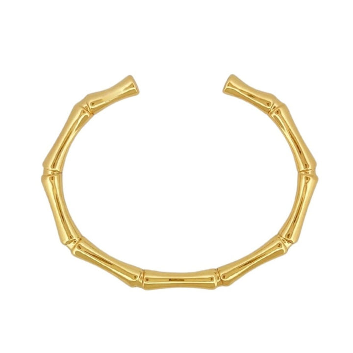 A nature-inspired Bamboo Bangle featuring a unique twist on a classic shape. Made from 14k recycled gold.