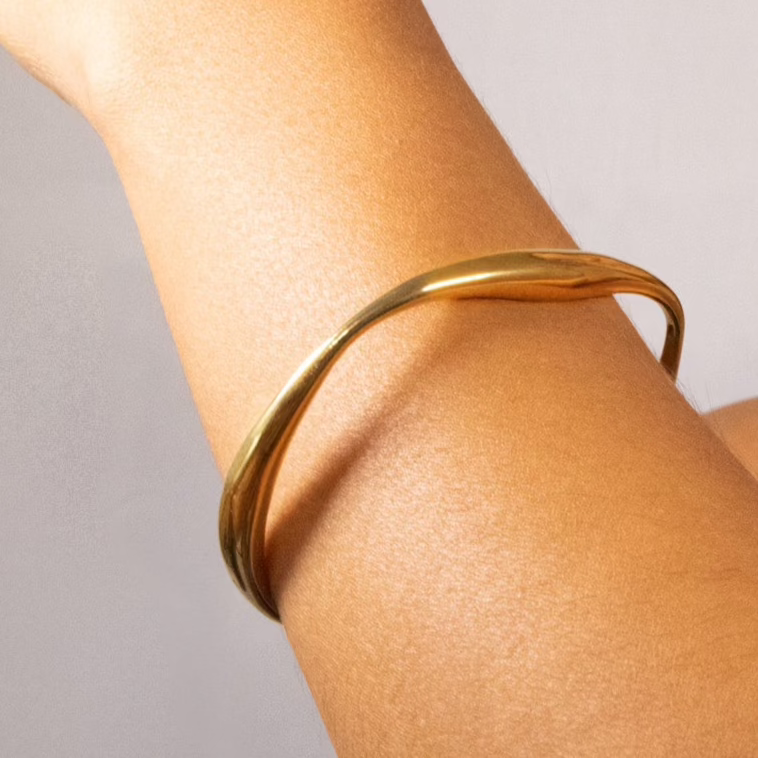 An irregular shaped bangle in gold or silver. Made from recycled gold and recycled silver. The perfect gift.