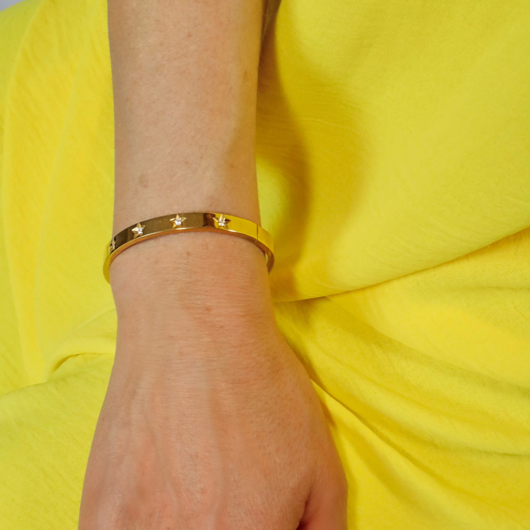 A gold bangle with sparkly Cubic Zirconia, the oval-shaped design fits comfortably around the wrist.