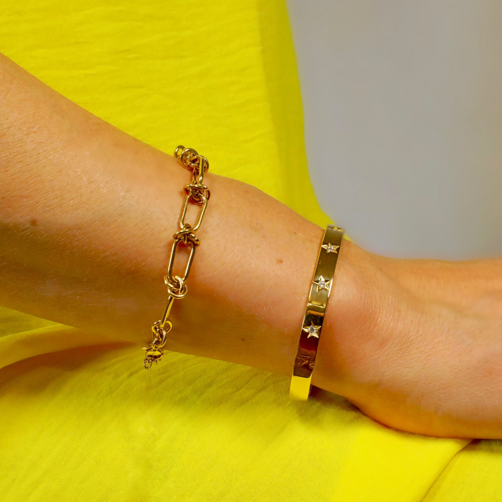 A gold bangle with sparkly Cubic Zirconia, the oval-shaped design fits comfortably around the wrist.