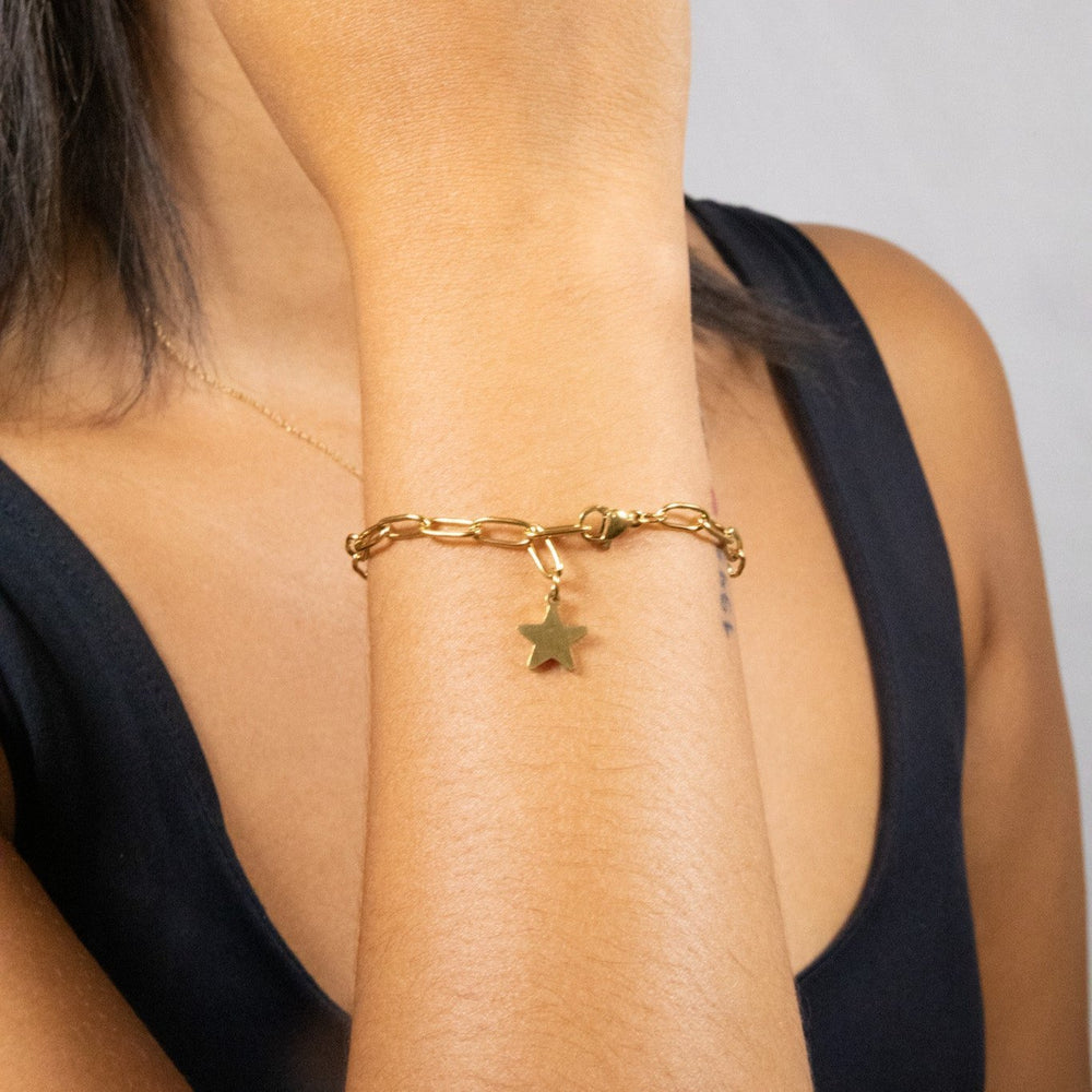 Paperclip bracelet with a star in gold. Adjustable to fit different wrists. Made from 100% recycled gold.