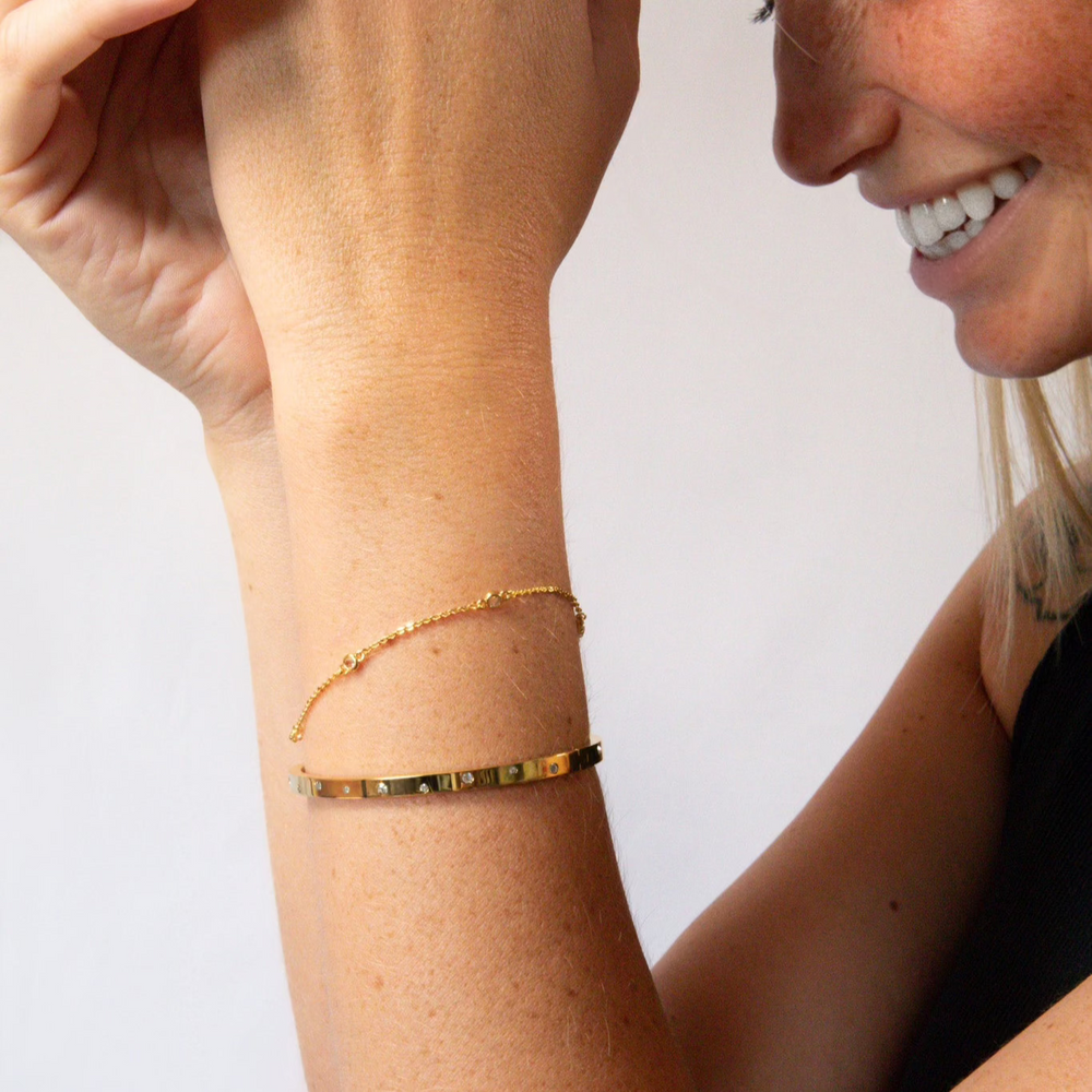 Un bracelet en or brillant. Il s'ouvre facilement grâce à une charnière. Fabriqué à partir d'or recyclé. Le cadeau idéal pour quelqu'un de spécial.