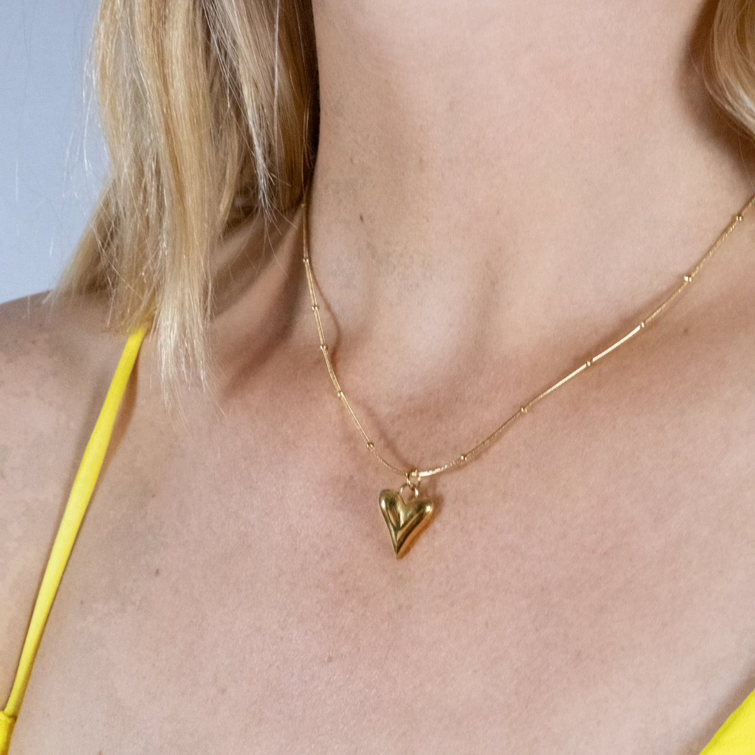 Een hartjesketting met bijpassende oorbellen. 

Un collier cœur avec des boucles d'oreilles assorties.

Een hartjesketting met bijpassende oorbellen.